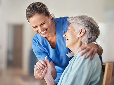 une infirmière et sa patiente échangent un sourire