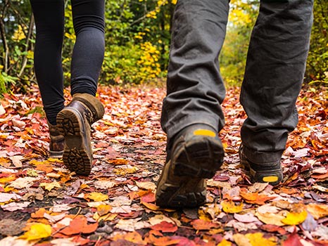 Close up of boots walking through autumn leaves